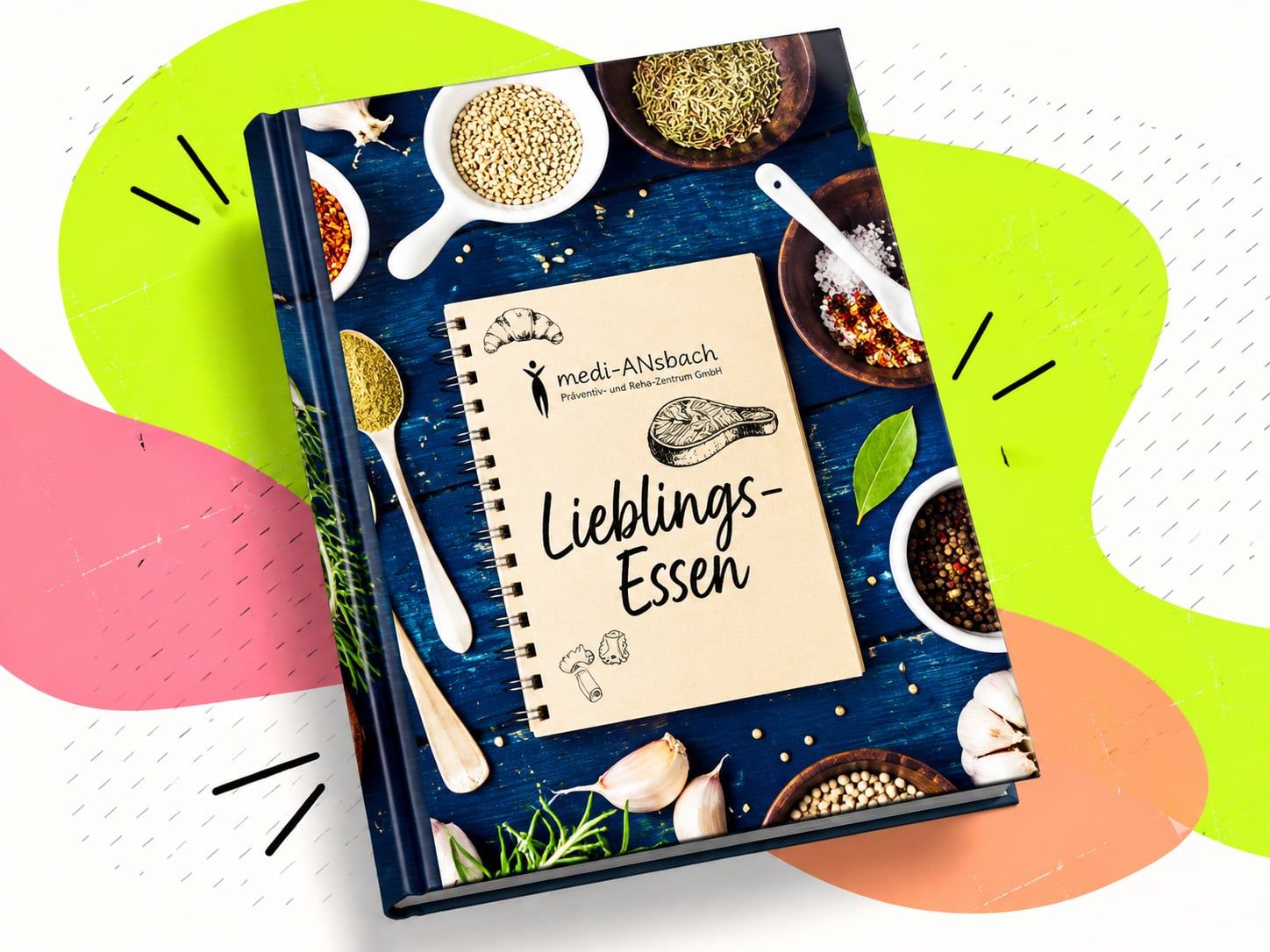 Gebundenes Kochbuch „Lieblings-Essen“ von medi-ANsbach, auf dem Cover ein Notizbuch zwischen Gewürzen, Kräutern und Knoblauch auf blauem Holz